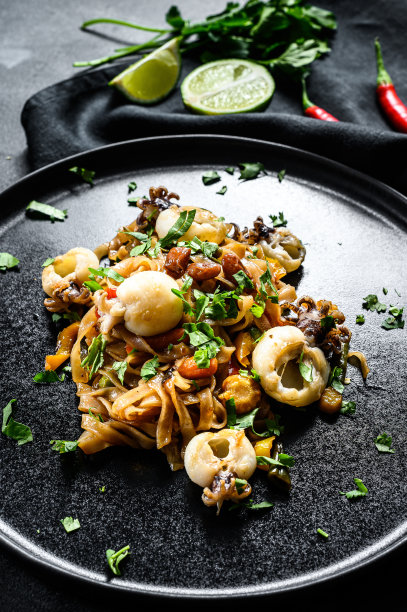 自制炒面，配海鲜和蔬菜。黑色背景。俯视图图片下载