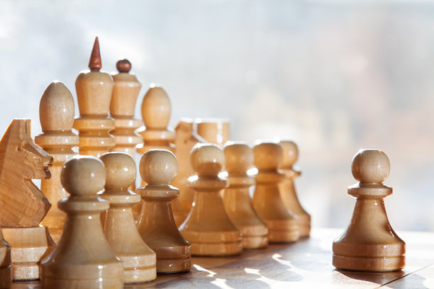 棋盘与白色木制棋子棋子前面和模糊的背景图片下载