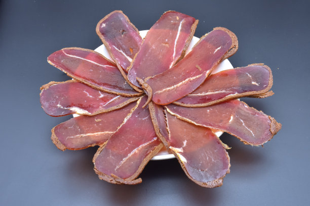 把basturma切片放在盘子里，摆成一个圆圈图片下载