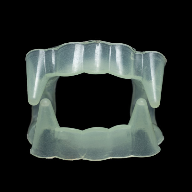 黑色背景上的塑料吸血鬼牙齿图片下载