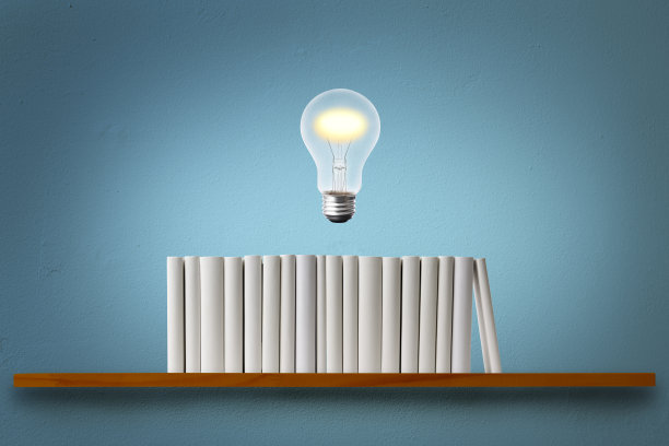 书架上那本空白的书上方的灯泡在半空中发光。图片下载