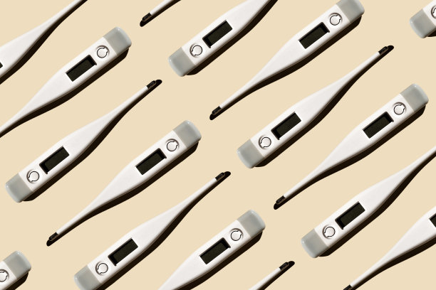 电子现代温度计的模式孤立在一个柔和的米色背景。发烧诊断、体检和保健理念图片下载