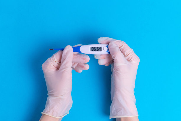 手戴橡胶手术手套，体温计符合正常体温36.6健康标准图片下载