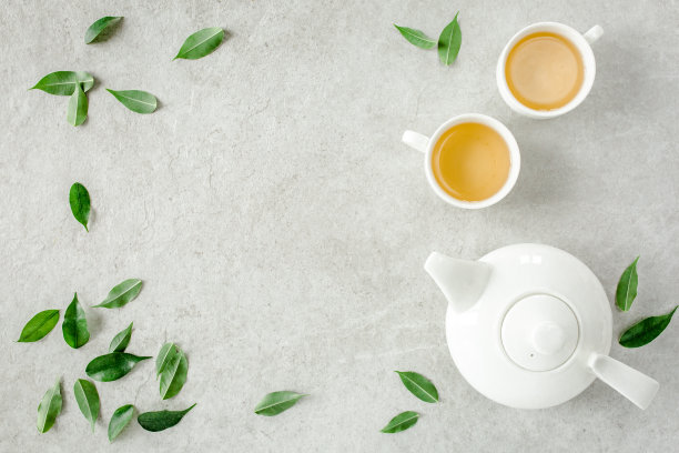 2个白茶杯和茶壶，配绿茶。平躺，俯视图。茶的概念图片下载