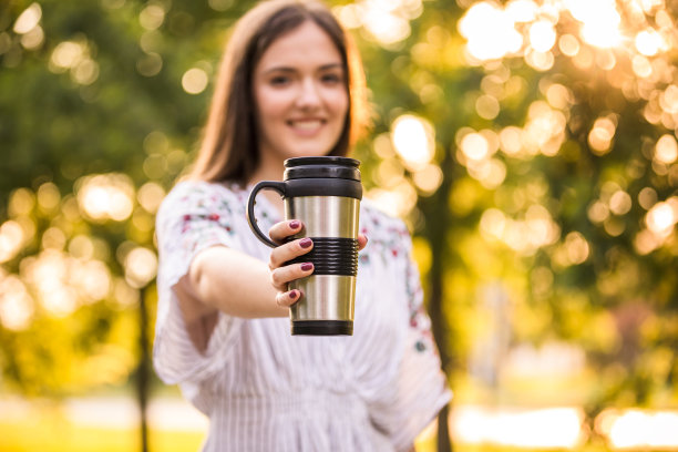 年轻女子享用可重复使用的咖啡杯图片下载
