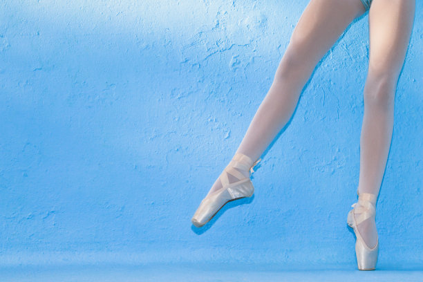 蓝色背景下穿着尖头鞋的小芭蕾舞者的腿图片下载