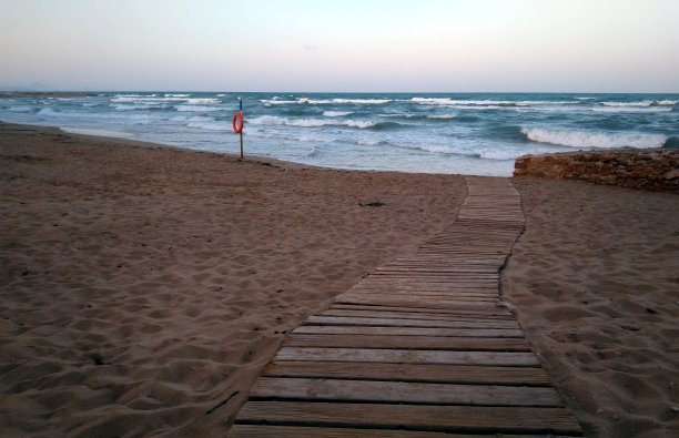 沙滩上有一条通向大海的木制栈道图片下载