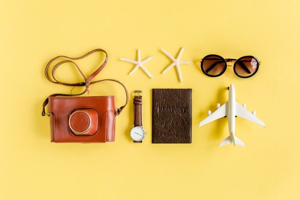 旅行者配件概念上的黄色背景。复古相机，飞机模型，飞机，太阳镜。夏天的背景图片下载