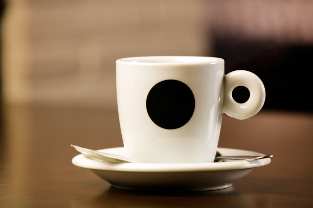 一杯新煮的热咖啡，放在木桌上，咖啡馆里面还有自由装饰的空间。图片下载