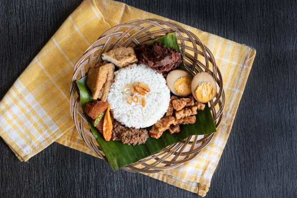 传统的爪哇古德格绿杰克水果甜炖在竹草板上，以深色木为背景图片下载