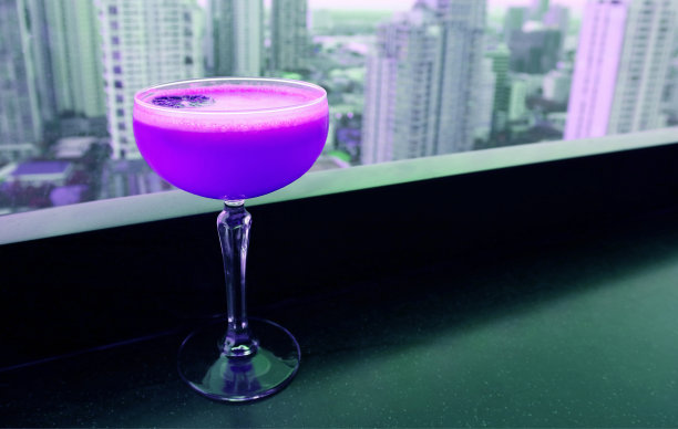 紫色鸡尾酒饮料与摩天大楼鸟瞰图的背景图片下载