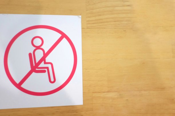 一个“不要坐在百货商店的木桌上”的标志，以保持城市中在冠状病毒爆发期间的社交距离图片下载