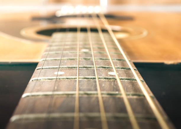 音乐概念:在柔和的灯光背景下弹奏原声吉他图片下载