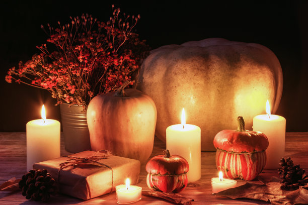 秋天的布局，南瓜，燃烧的蜡烛和橙色的花在篮子里。感恩节的概念素材图片