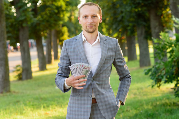 年轻成功的商人手里拿着钱。图片下载