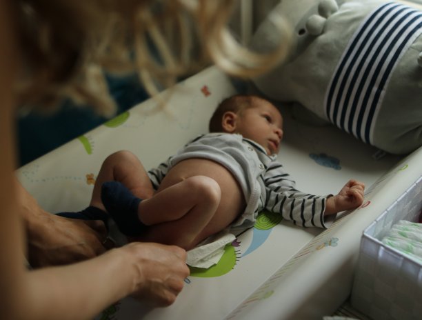 可爱的婴儿在卧室换尿布，婴儿和女人图片下载