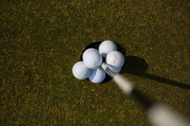 洞里有很多高尔夫球，旗杆也在洞里图片下载