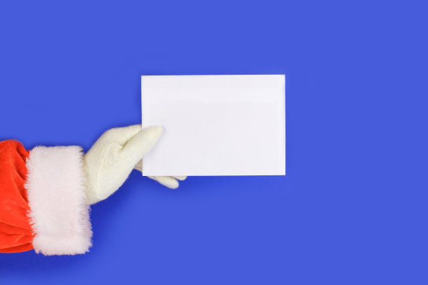 圣诞老人的手举着一个白色的公告牌在蓝色的背景图片下载