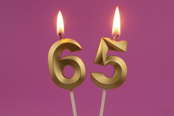 粉红色背景上的金色生日蜡烛，数字65图片下载