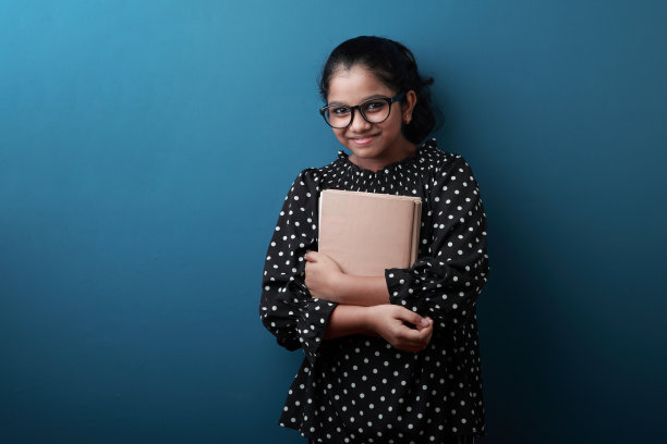 快乐的年轻女孩手里拿着笔记图片下载