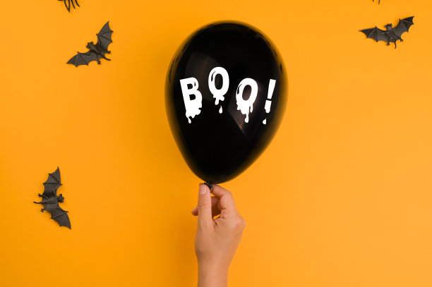 万圣节快乐!手和球上写着“BOO!”橙色背景的创意海报。高质量的照片。本空间图片下载