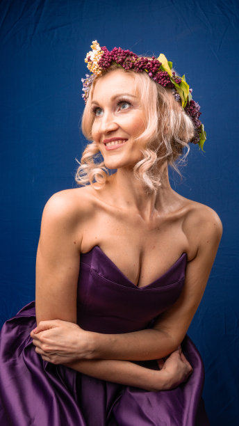 幸福的绿色美妙在一个淡紫色花环与白人外表有乐趣的蓝色背景，与明亮的日光图片下载