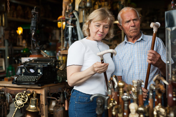 在跳蚤市场上，一群老人和一群妇女正在检查一根罕见的手杖图片下载
