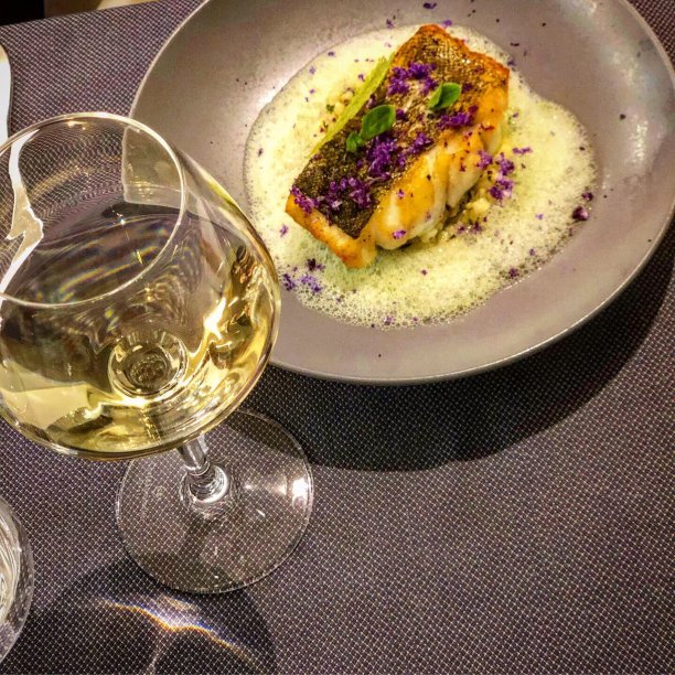 盘子，烤鱼和一杯白葡萄酒图片下载