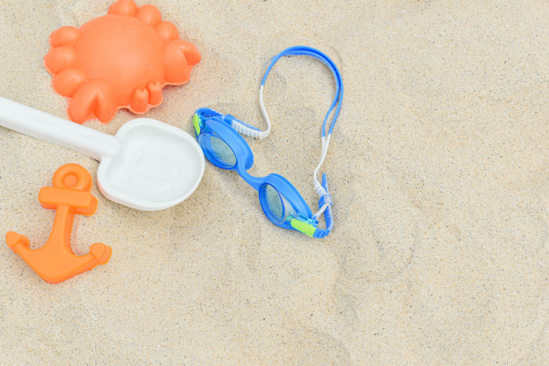 潜水眼镜旁边是沙玩具。图片下载