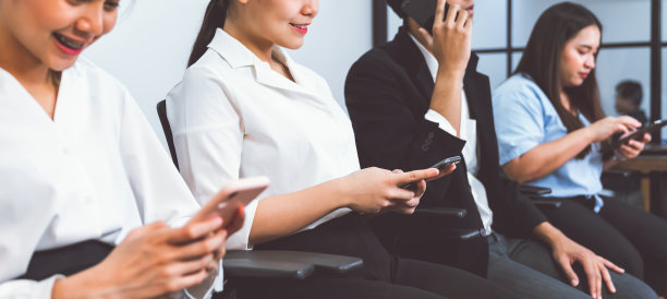 亚洲商务人士坐在办公室的椅子上使用智能手机与客户联系。工作团队合作概念。图片下载