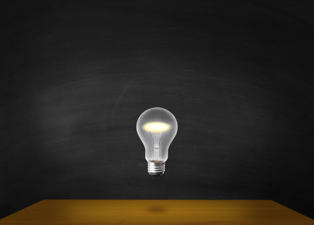 靠在黑板上的木桌上方，灯泡在半空中闪闪发光。图片下载