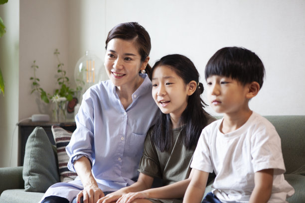 母亲和两个孩子一起坐在沙发上图片下载