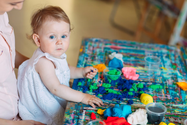 母亲和女儿在玩动沙。图片下载