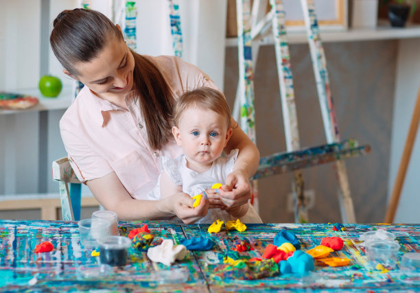母亲和女儿在玩动沙。图片下载