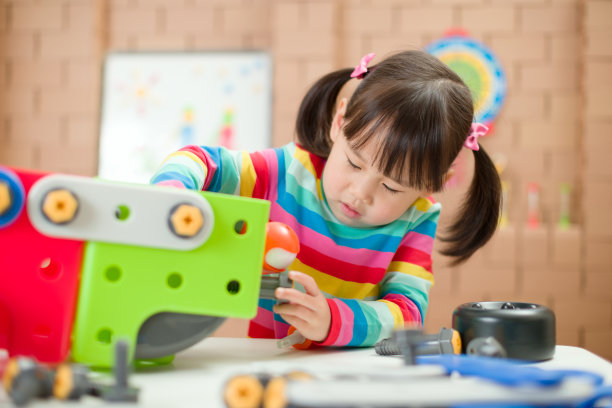 年轻女孩玩创造性玩具积木在家上学图片下载