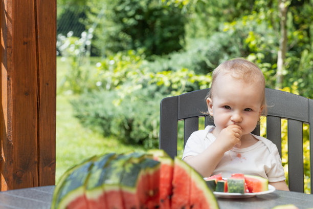 小男孩在吃西瓜看镜头。图片下载
