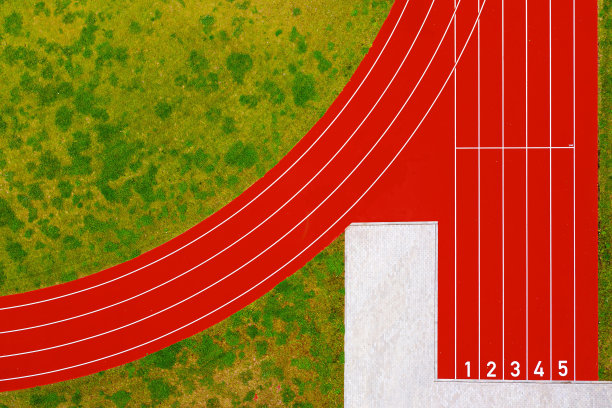 从上到下的红色跑道与数字和绿色草地草坪，体育活动的基础设施图片下载