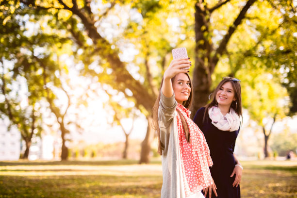 秋天在公园里自拍的女人图片下载