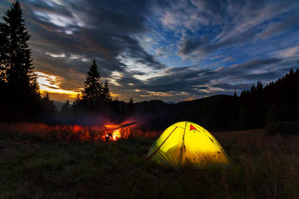 乌克兰喀尔巴阡山脉的傍晚。草坪上的帐篷在夕阳的背景下闪闪发光。在山里露营。图片下载