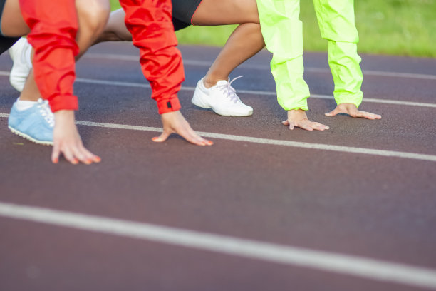 特写的手的两个高加索运动员站在跑道上跑步准备。水平的形象图片下载