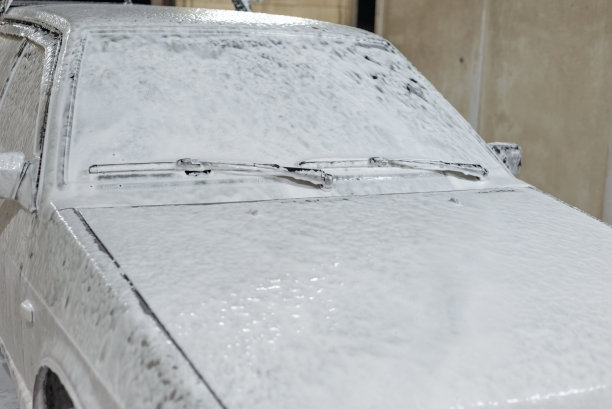 洗车处的泡沫汽车。用肥皂水处理后的脏车图片下载