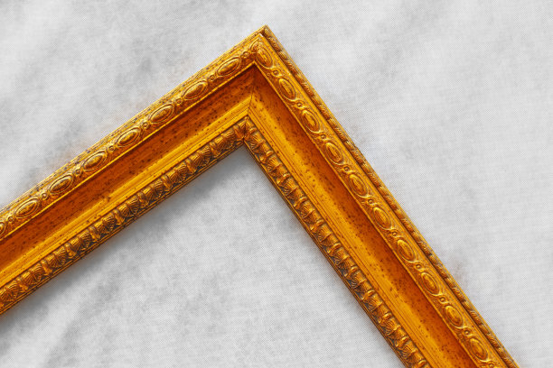 的黄金框架。浅灰色背景下的金色空相框的一部分。从没有照片的相框角度图片下载