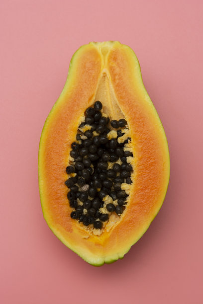 番木瓜果实孤立在粉红色的背景。奇异的甜果。图片下载