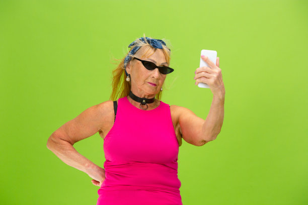 妇女在超级时髦的服装孤立在明亮的绿色背景图片下载