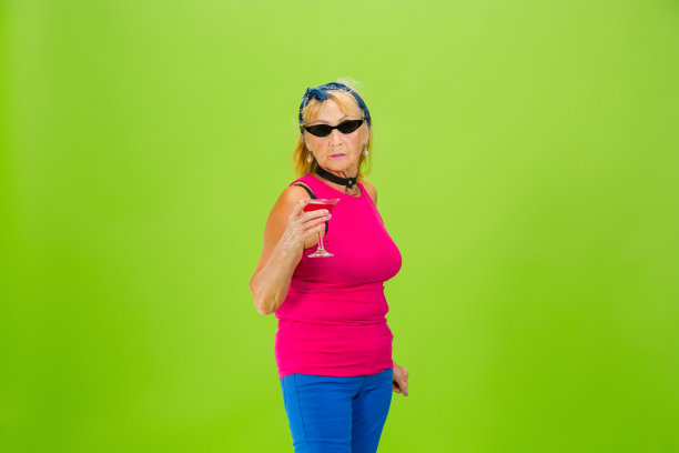 妇女在超级时髦的服装孤立在明亮的绿色背景图片下载