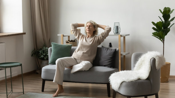 平静满足成熟的女人放松在舒适的沙发在家里图片下载