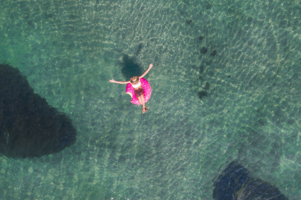 鸟瞰图上的女人漂浮在湖上充气床垫日光浴图片下载