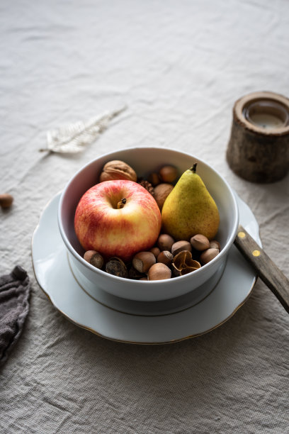 一张秋季餐桌，白色的碗里装着新鲜的水果和坚果图片下载