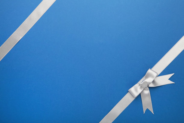 蓝色背景上的银色丝带和蝴蝶结。图片下载