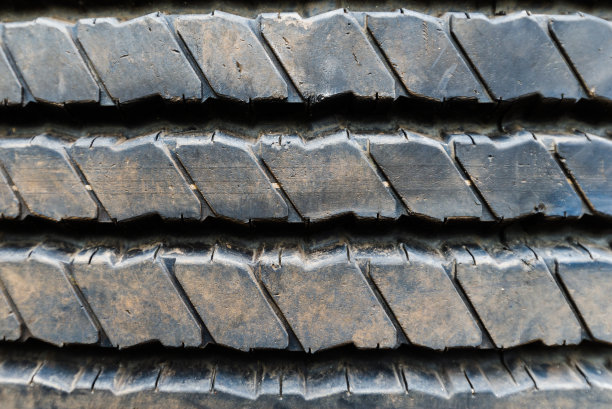 俯视图的轮胎表面显示花纹胎面磨损和污染的灰尘从道路。图片下载